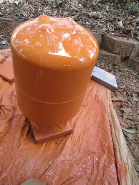 A helium tank that has been painted orange.