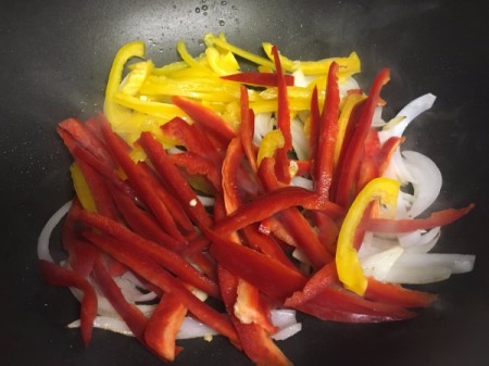 cut onions with sliced red and yellow peppers