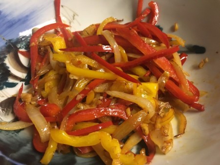 cooked onions with sliced red and yellow peppers moved to bowl