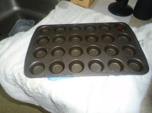 A mini muffin tin on a white towel in the kitchen.