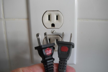 Two electrical plugs with red dots on the top side.