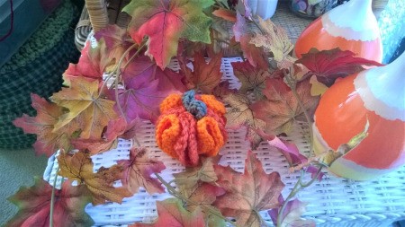 Cute Little Crochet Circle Pumpkin - finished pumpkin in a bed of faux fall leaves