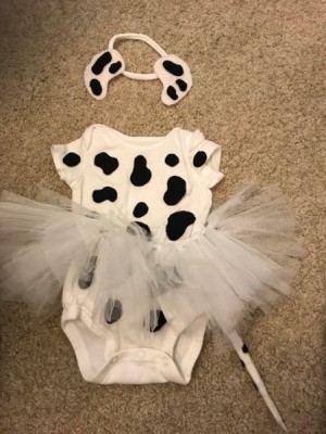 A dalmation puppy costume for a baby, with a onesie, a tutu and a headband with ears.