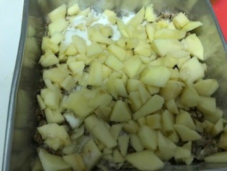 chopped apples on top of mixture in pan