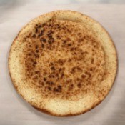 A store-bought pizza crust after prebaking.