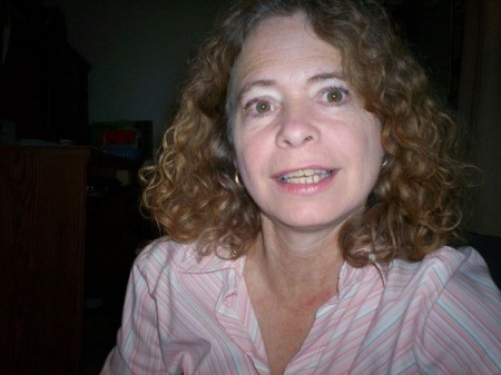 A woman with curly shiny hair, after using a honey hair treatment.