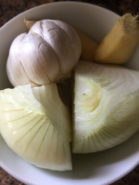 onion, quartered and garlic and ginger in bowl