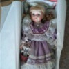 Value of a Porcelain Doll - doll wearing a lavender dress in box