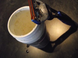 A razor blade next to a container of coconut oil.