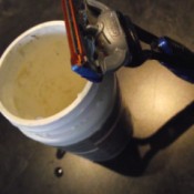 A razor blade next to a container of coconut oil.