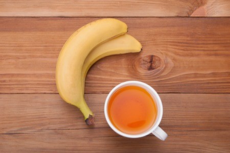 Banana and Tea on a wood surface.