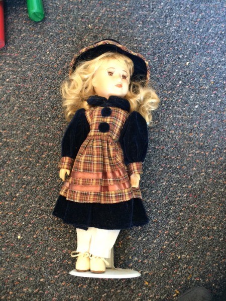 Identifying Porcelain Dolls - blonde doll with plaid apron over dark dress with matching hat