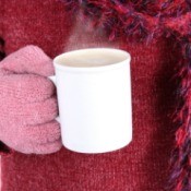 Gloved Hand Holding Mug of Hot Chocolate