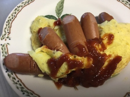 hot dogs on an omelet with catsup