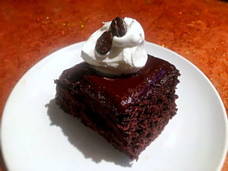 Coffee Crunch Chocolate Cake with whipped cream on plate