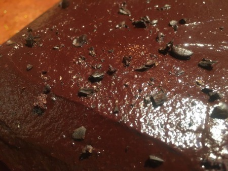 adding coffee beans to frosted Chocolate Cake