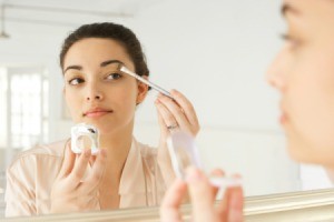 Woman Applying Makeup in the Mirror