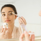 Woman Applying Makeup in the Mirror