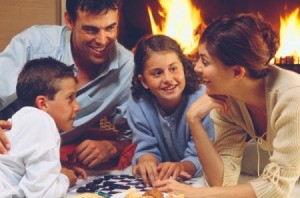 Family Playing Checkers by Fire