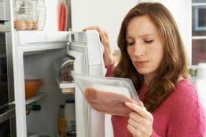 Woman Looking at Expiration Date of Deli Meat