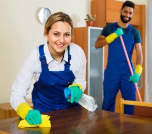 Two people cleaning a house