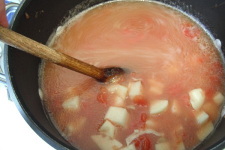 adding both tomatoes and potatoes to pan
