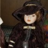 Identifying a Porcelain Doll - doll wearing a dark jacket and matching hat over a floral skirt