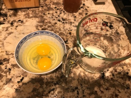 eggs in bowl and yeast in measuring cup