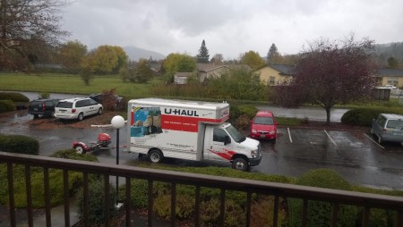 A moving truck parked outside an apartment.