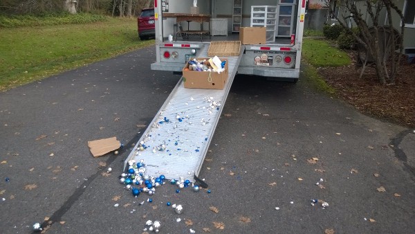 A moving truck's ramp with items that have fallen out of boxes.