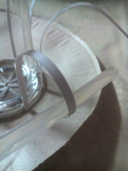 Decorative Recycled Drinking Glass Stand - curl the ends of the fasteners around a pencil of unused glue stick