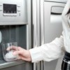 Woman Getting Ice From Refrigerator