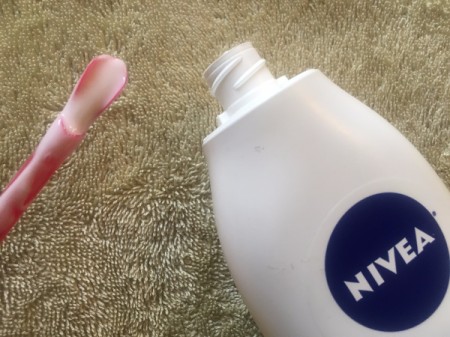 A Slurpee straw being used to remove lotion from a bottle.