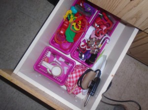 A drawer organized with small containers.