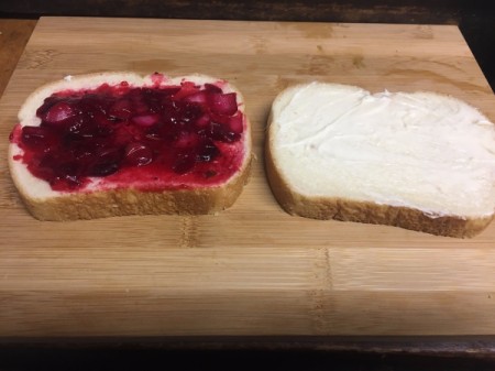Mayonnaise and cranberries spread on bread
