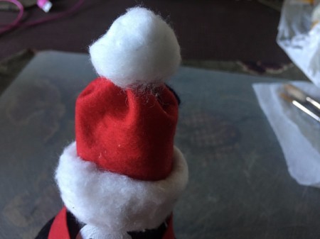 Upcycled Light Bulb Penguin - pinch the felt and make it cone shaped and add a cotton ball pom, unravel another cotton ball and glue around base of hat