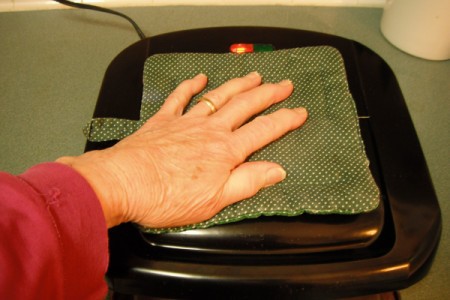 closed grill with hotbed and hand on top