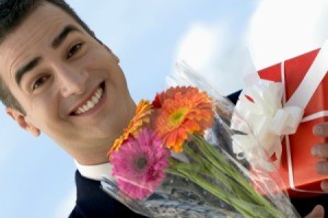 Happy man holding flowers and gift.