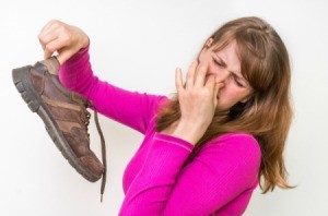 Woman holding dirty stinky shoes