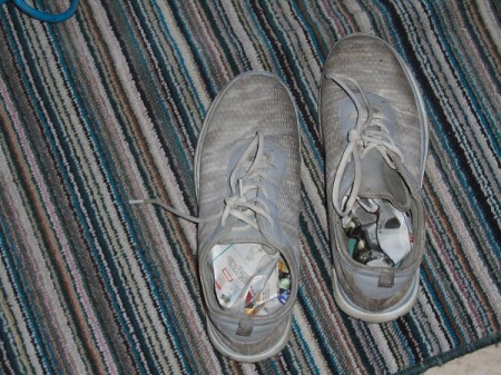 Tennis shoes with newspaper stuffed inside for drying.