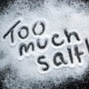"Too Much Salt" written in salt on black table.