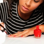 Woman painting her nails red.