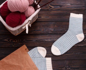 Balls of yarn and socks on a table.