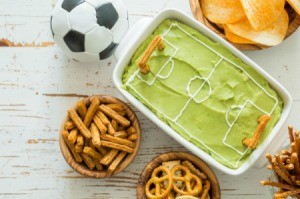 Soccer field dip, soccer ball and snacks on table.