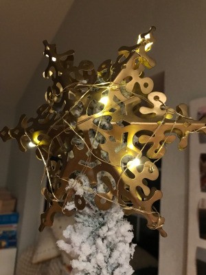 A light strand wrapped around a star tree topper.