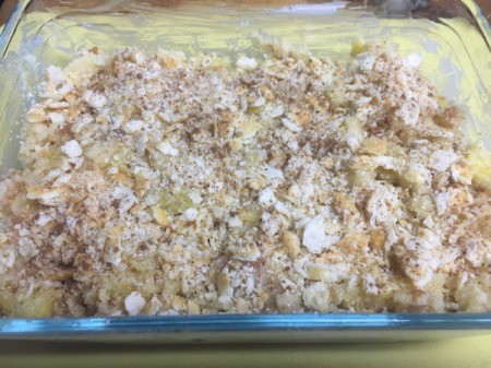 Pineapple Bread in baking dish covered with crumbled crackers and cinnamon