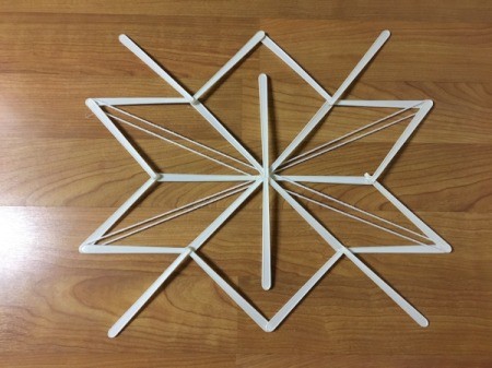 Stick and Yarn Snowflake Decoration - glue yarn down to center on each pass