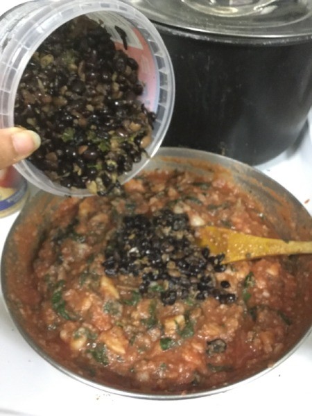 adding black beans to skillet