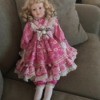 Identifying an Antique Porcelain Doll - blond doll with ringlets and wearing a pink and white floral dress