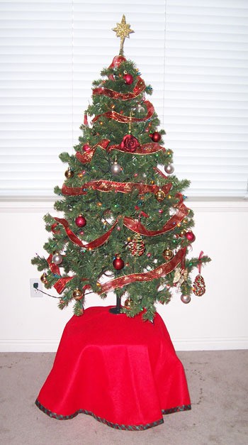 A Christmas tree on a high table.